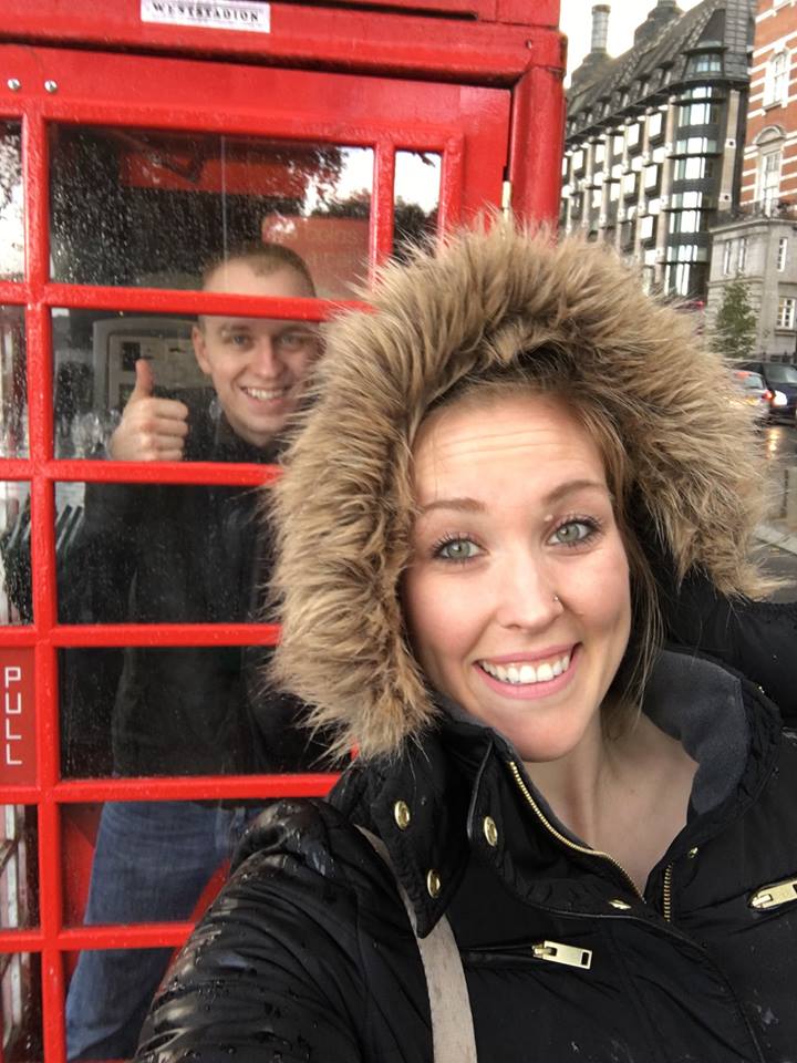 Ben and Erinn posing with a red telephone booth.