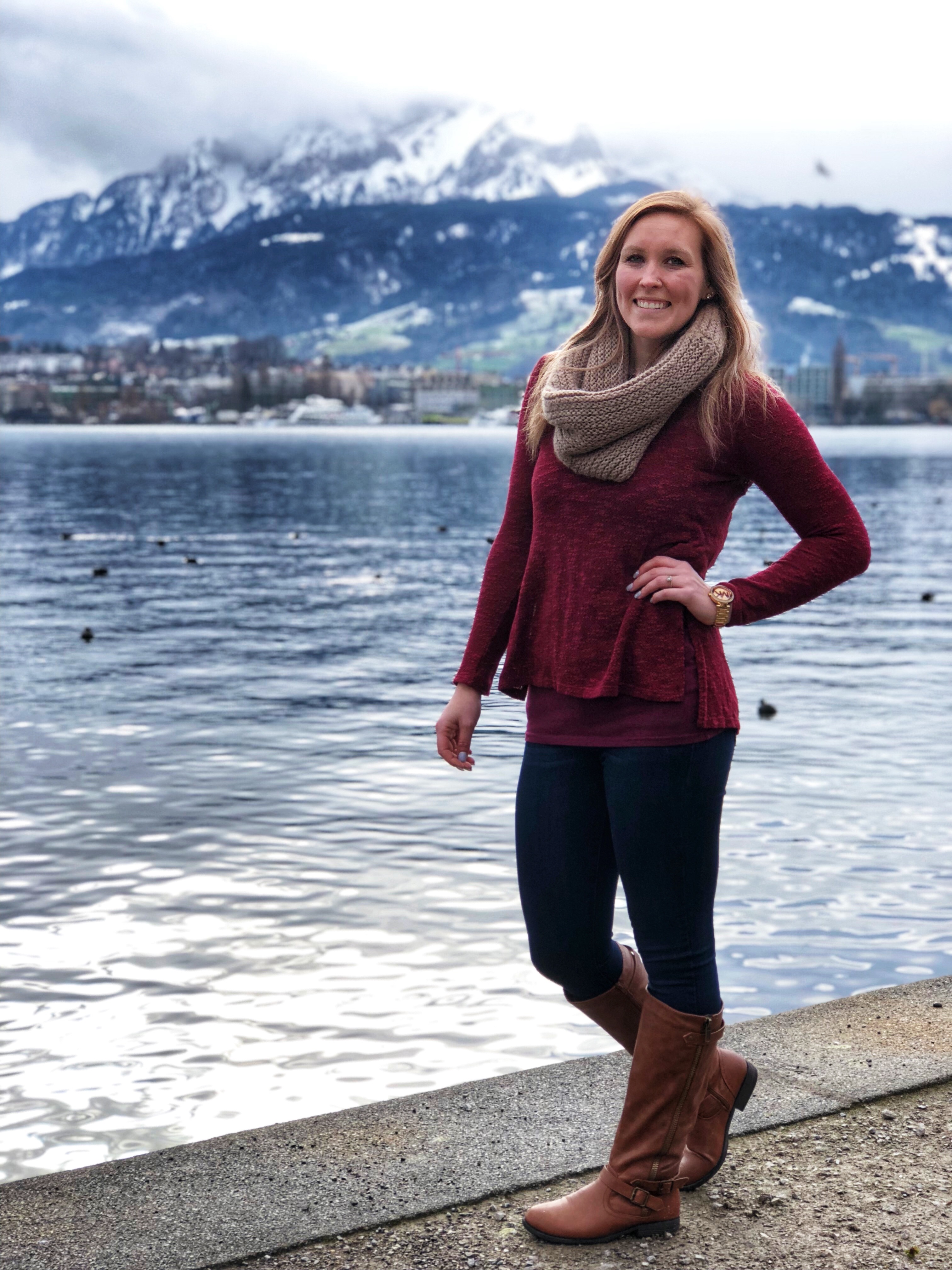 Erinn standing in front of Lake Lucerne with the snowcapped Alps in the background.