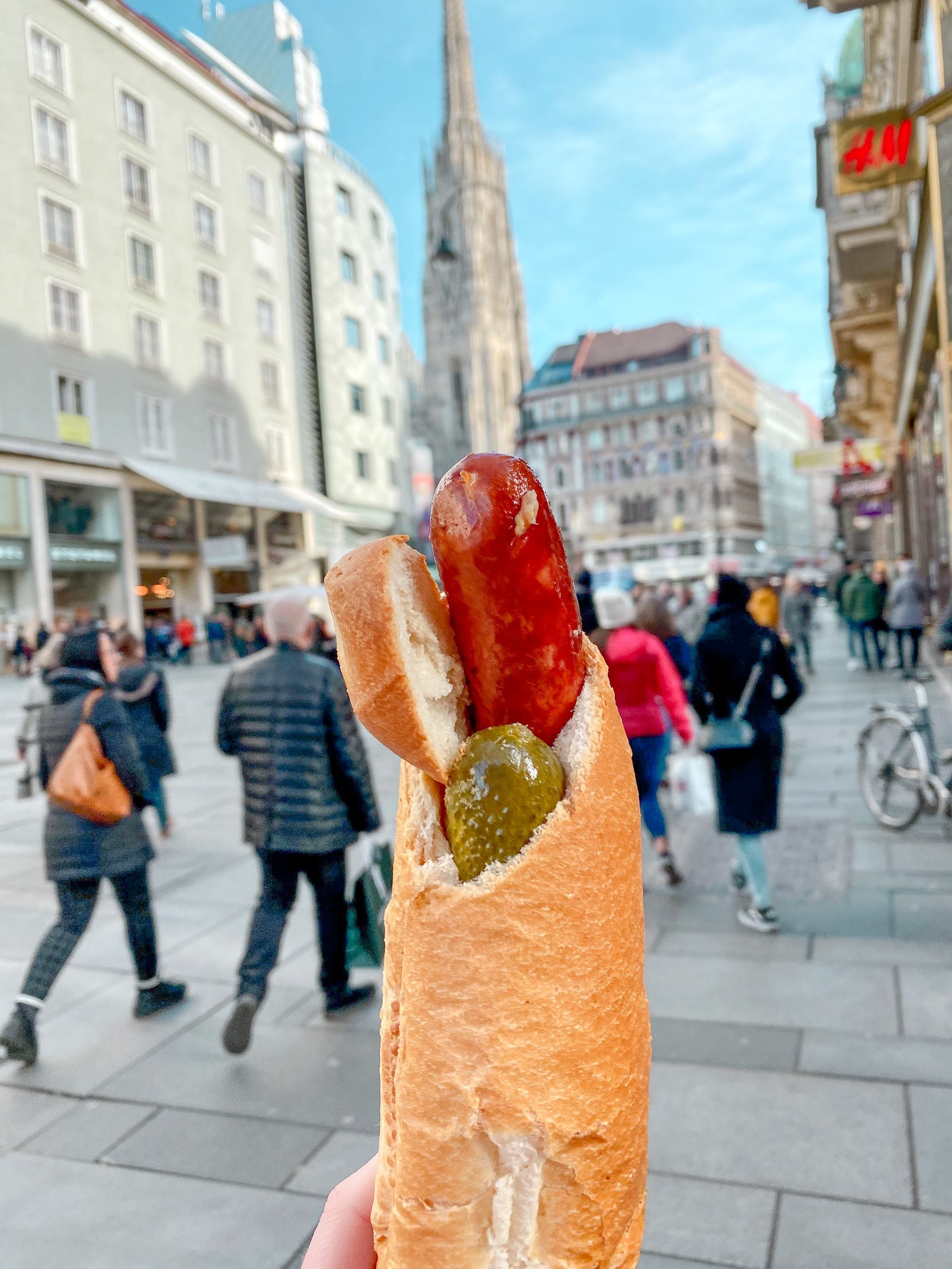 A wiener (sausage/brat) stuffed with sauerkraut, a pickle, ketchup and mustard in Vienna, Austria.