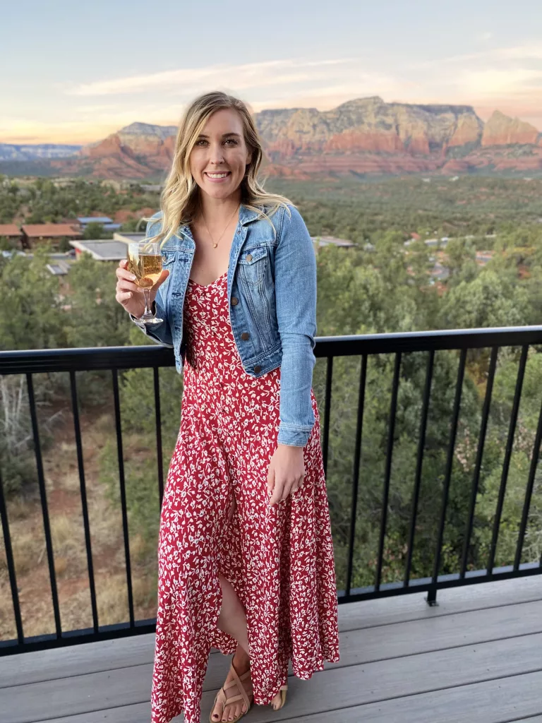 Erinn smiles for a picture while enjoying a glass of wine on the AirBnb balcony in Sedona.