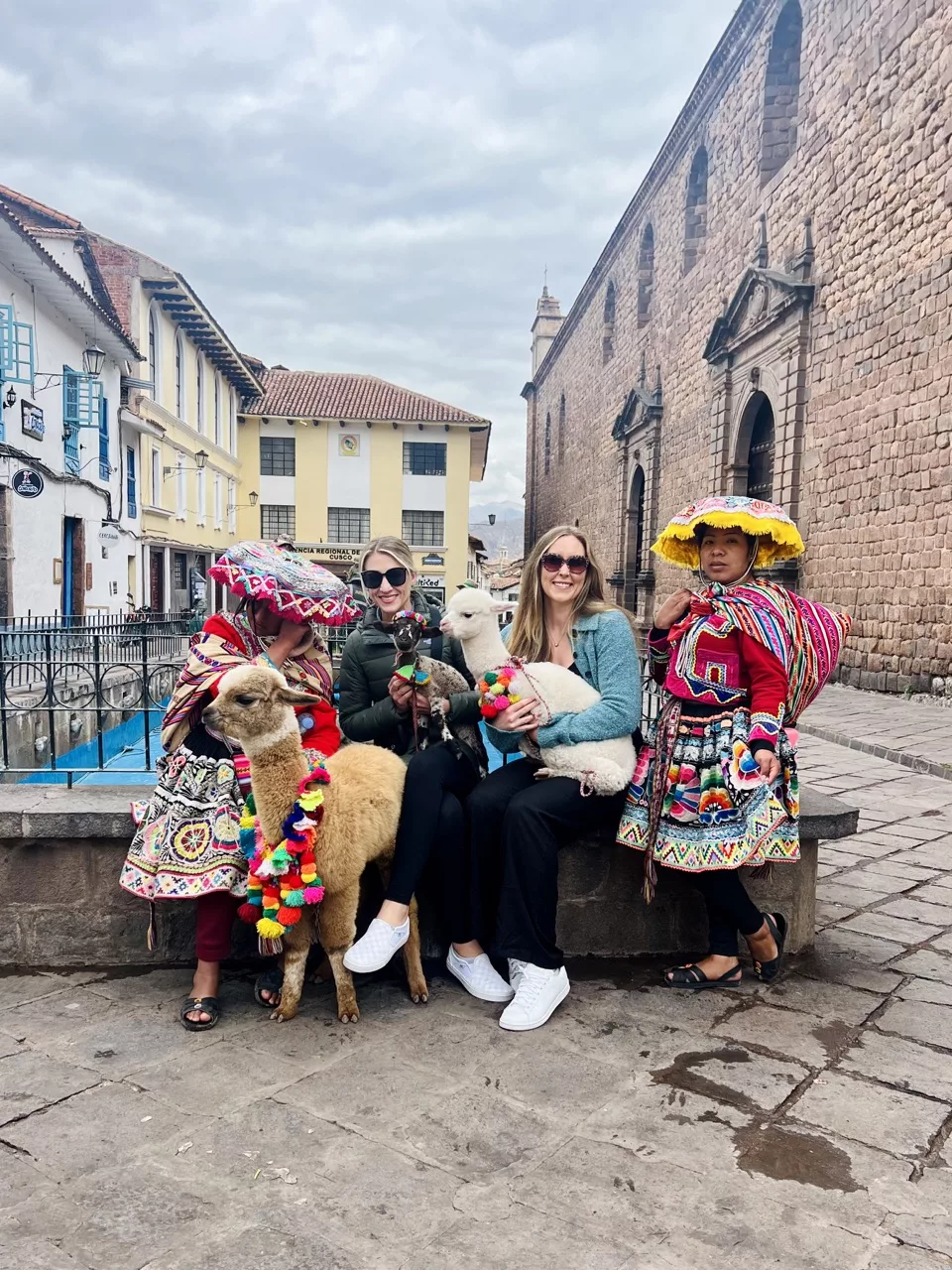 Olivia and Erinn hold baby alpacas in Cusco.